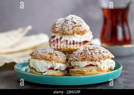 Kuchen mit Himbeersoße und Rahm. Gebäck. Snack-Kuchen auf dunklem Hintergrund. Nahaufnahme Stockfoto