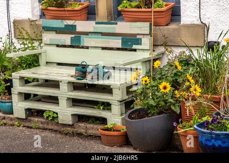 Upcycling Holzpaletten, um eine Bank zu machen, die von Spaziergängern benutzt wird, um ihre müden Füße auszuruhen Stockfoto