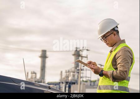 Asiatischer Mann petrochemischen Ingenieur, der in Öl- und Gasraffinerie-Fabrik Industriefabrik arbeitet, die Menschen Arbeiter Mann Ingenieur Arbeitskontrolle im Kraftwerk ene Stockfoto