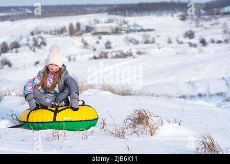 Mädchen lachinh während Schnee tubing Stockfoto