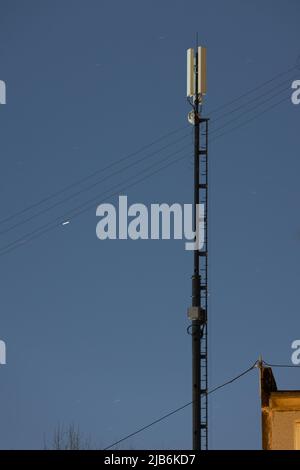 Langer, leichter Internet-Telekommunikations-Rohrturm mit 4G und 5G Sendern in der Nacht Stockfoto