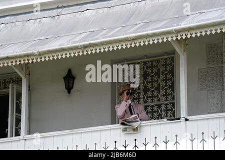 Ein Rennfahrer auf der Tribüne wacht durch ein Fernglas vor dem Cazoo Woodcote British EBF Stakes on Ladies Day während des Cazoo Derby Festival 2022 auf der Epsom Racecourse, Surrey. Bilddatum: Freitag, 3. Juni 2022. Stockfoto