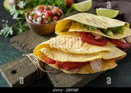 Gesundes Mittagessen. Tortilla-Sandwich, mexikanische Wraps mit gegrilltem Hähnchenfilet und Avocado, serviert mit Guacamole. Stockfoto