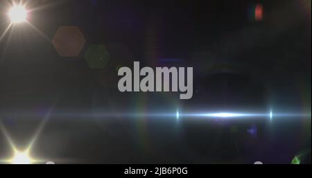 Bild eines Scheinwerfers mit Streulicht und Lichtstrahl, der sich über einen dunklen Hintergrund bewegt Stockfoto