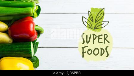 Bild von Superfoods Text in grün über frischem Bio-Gemüse auf Holzbrettern Stockfoto