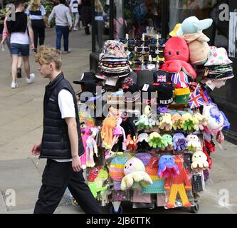 Manchester, Großbritannien, 3.. Juni 2022. Die Leute laufen am Wagen eines Straßenverkäufers vorbei und verkaufen Hüte, Spielzeug und Souvenirs. Tägliches Leben auf den Straßen von Manchester, England, Großbritannien und den Britischen Inseln am zusätzlichen Jubilee Bank Holiday Freitag. Am Freitag, dem 3.. Juni, ist der offizielle Bankfeiertag des Platinum Jubilee, ein zusätzlicher Bankfeiertag zur Feier des 70.-jährigen Bestehens der Königin als Monarch. Quelle: Terry Waller/Alamy Live News Stockfoto