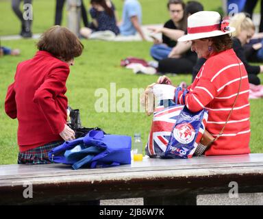 Manchester, Großbritannien, 3.. Juni 2022. Zwei Frauen, eine mit einer Union Jack-Tasche, ruhen sich in Piccadilly Gardens, im Zentrum von Manchester, aus. Tägliches Leben auf den Straßen von Manchester, England, Großbritannien und den Britischen Inseln am zusätzlichen Jubilee Bank Holiday Freitag. Am Freitag, dem 3.. Juni, ist der offizielle Bankfeiertag des Platinum Jubilee, ein zusätzlicher Bankfeiertag zur Feier des 70.-jährigen Bestehens der Königin als Monarch. Quelle: Terry Waller/Alamy Live News Stockfoto