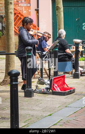 Blick auf die George Street, die Hastings Old Town, eine lebhafte Butler's Gap, mit Straßenmusikern, East Sussex, Großbritannien Stockfoto