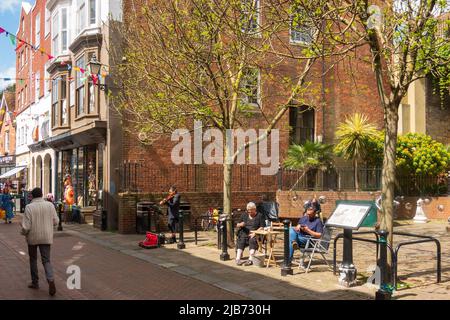 Blick auf die George Street, die Hastings Old Town, eine lebhafte Butler's Gap, mit Straßenmusikern, East Sussex, Großbritannien Stockfoto