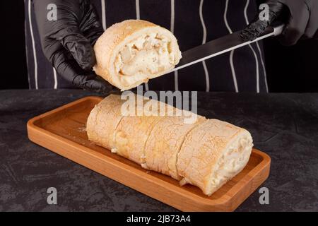 Dessert-Meringue-Rolle mit frischer Birne auf dunklem Hintergrund in einem Café. Speicherplatz kopieren Stockfoto