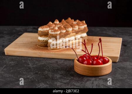 Dessert Tiramisu Kuchen auf einem Tablett auf dunklem Hintergrund in einem Café Stockfoto