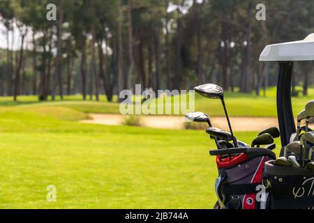 Satz von Golfschlägern in Golftaschen auf der Rückseite eines Golfwagens auf einem wunderschönen Golfplatz Stockfoto