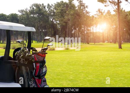 Satz von Golfschlägern in Golftaschen auf der Rückseite eines Golfwagens auf einem wunderschönen Golfplatz Stockfoto