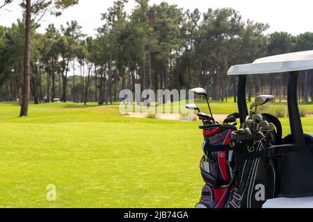 Satz von Golfschlägern in Golftaschen auf der Rückseite eines Golfwagens auf einem wunderschönen Golfplatz Stockfoto