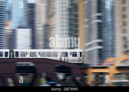 Hochzug in Chicago, der über die Eisenbahnbrücke gegen Wolkenkratzer im Stadtzentrum fährt. Stockfoto