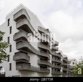 Öko-Nachbarschaft. Nahaufnahme einer weißen Gebäudefassade mit Metallbalkonen Stockfoto