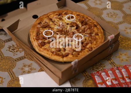 Double Chicken Pizza auf dem Tisch Stockfoto