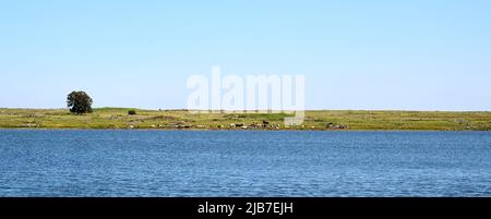 Panoramablick auf den See Shabania in den Golanhöhen mit Blick auf eine grüne Ebene und eine Bergkette in der Ferne. Eine hohe Auflösung. Stockfoto