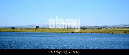 Panoramablick auf den See Shabania in den Golanhöhen mit Blick auf eine grüne Ebene und eine Bergkette in der Ferne. Eine hohe Auflösung. Stockfoto