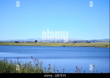 Panoramablick auf den See Shabania in den Golanhöhen mit Blick auf eine grüne Ebene und eine Bergkette in der Ferne. Eine hohe Auflösung. Stockfoto