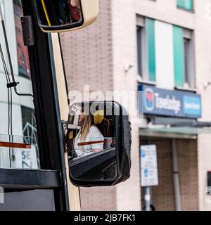 Epson Surrey, London, Großbritannien, Juni 03 2022, Frau Busfahrerin Reflektion in ihrem Rückspiegel für Fahrer, der am Travellodge Hotel vorbeifährt Stockfoto