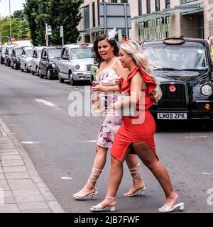 Epson Surrey, London, Großbritannien, 03 2022. Juni, Two Young Women Crossing Road in modischen engen Kleidern Stockfoto
