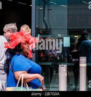 Epson Surrey, London, Großbritannien, Juni 03 2022, Schwarze Frau mit Red hat vor der Epsom Station Stockfoto