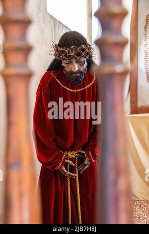 Ein Bild von Jesus Christus, wie von einem Künstler in Form einer Statue, gerahmt zwischen zwei Geländern, auf einer Treppe in einer Kirche vorgestellt. Stockfoto