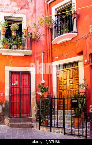 Eine Duplix-Wohnung in der mexikanischen Stadt Guanajuato, Guanajuato, Mexiko, orange gestrichen. Stockfoto