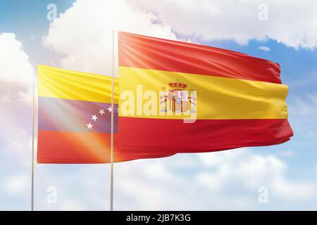 Sonniger blauer Himmel und Flaggen von spanien und venezuela Stockfoto