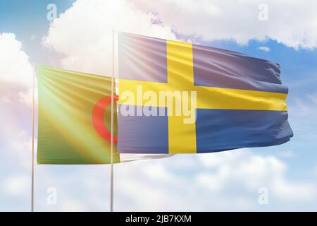 Sonniger blauer Himmel und Flaggen von schweden und algerien Stockfoto