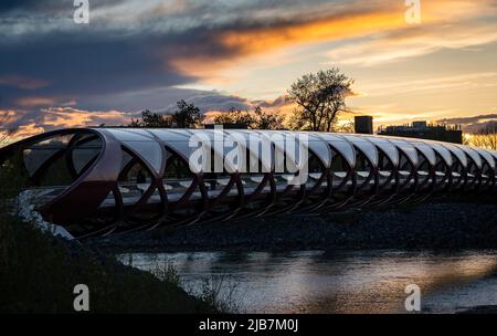 Eine Fußgängerbrücke bei Sonnenuntergang an einem beliebten Touristenziel in der Nähe des Princess Island Park in Calgary, Alberta, Kanada. Stockfoto