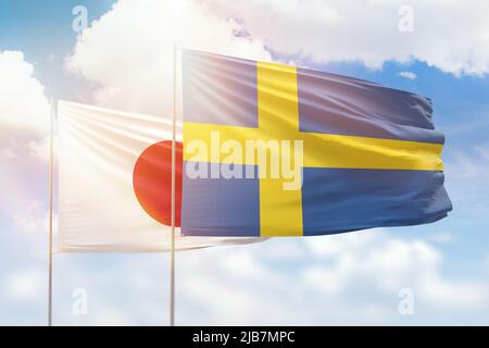Sonniger blauer Himmel und Flaggen von schweden und japan Stockfoto