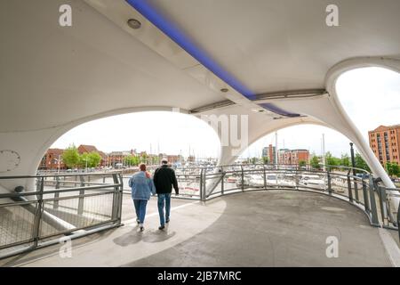 Hull, East Yorkshire, Großbritannien, 21. Mai 2022 Murdoch's Connection, Eine neue Fußgängerbrücke, die das Zentrum von Hull mit der Marina verbindet. Zwei Fußgänger gehen vorbei. Stockfoto