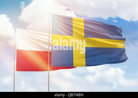 Sonniger blauer Himmel und Flaggen von schweden und polen Stockfoto