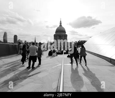 London, Greater London, England, Mai 21 2022: Blick von One New Change auf die St. Pauls Cathedral, während die Menschen sitzen, sich entspannen, Kontakte knüpfen und die Aussicht genießen. Stockfoto