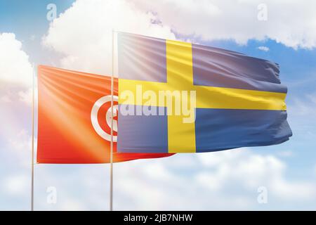 Sonniger blauer Himmel und Flaggen von schweden und tunesien Stockfoto