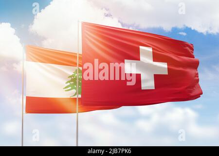 Sonniger blauer Himmel und Flaggen der schweiz und des libanon Stockfoto