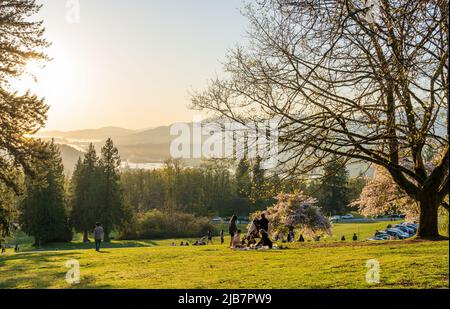 Burnaby, BC, Kanada - 18 2021. April : Burnaby Mountain Park bei Sonnenuntergang. Die Leute, die hier ein Picknick machen und Kirschblüten während des Frühlings genießen Stockfoto