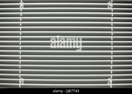 Jalousien am Fenster. Klappen zum Schutz vor Licht. Details zur Innenausstattung. Fenster im Büro. Stockfoto
