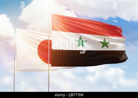 Sonniger blauer Himmel und Flaggen von syrien und japan Stockfoto