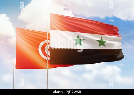 Sonniger blauer Himmel und Flaggen von syrien und tunesien Stockfoto