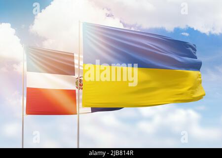 Sonniger blauer Himmel und Flaggen der ukraine und der dominikanischen republik Stockfoto