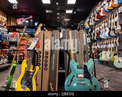 Lynnwood, WA USA - ca. Mai 2022: Ansicht verschiedener Gitarren zum Verkauf in einem Gitarrencenter Musikinstrumentengeschäft. Stockfoto