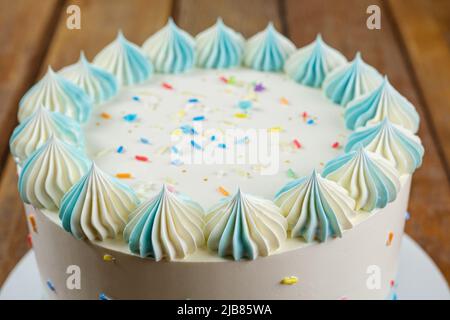 Nahaufnahme der Spitze der kreisförmigen Vanillekuchen mit Buttercreme, die in Form von zefir zuckert. Stockfoto