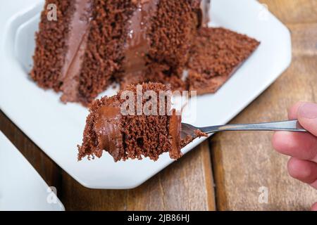 Nahaufnahme eines Stücks Schokoladenkuchen mit einer halbsüßen Ganache-Füllung aus Schokolade. Stockfoto