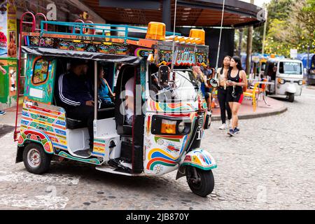 Guatape, Antioquia - Kolumbien - 25. Mai 2022. Motor-Dreiräder, dekoriert als traditionelle chivas in der Touristenstadt Guatapé. Stockfoto