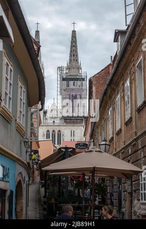 Bild der Skalisna ulica Straße in Zagreb, Kroatien, im Sommer mit Menschen sitzen in Bars und Cafés und der Turm der Kathedrale von Zagreb in Backgroun Stockfoto