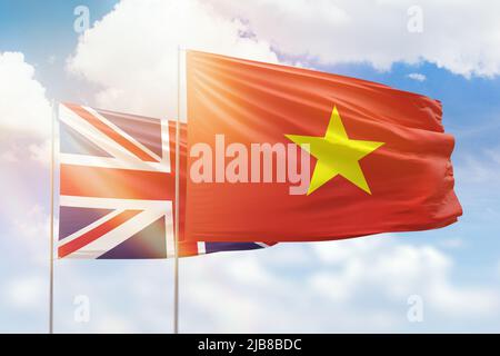 Sonniger blauer Himmel und Flaggen von vietnam und großbritannien Stockfoto