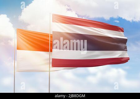 Sonniger blauer Himmel und Flaggen von thailand und indonesien Stockfoto